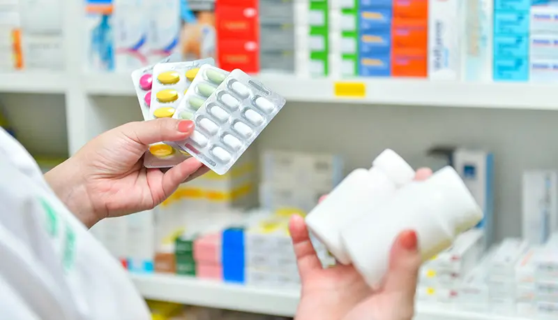Medicines being checked at a pharmacy shelf